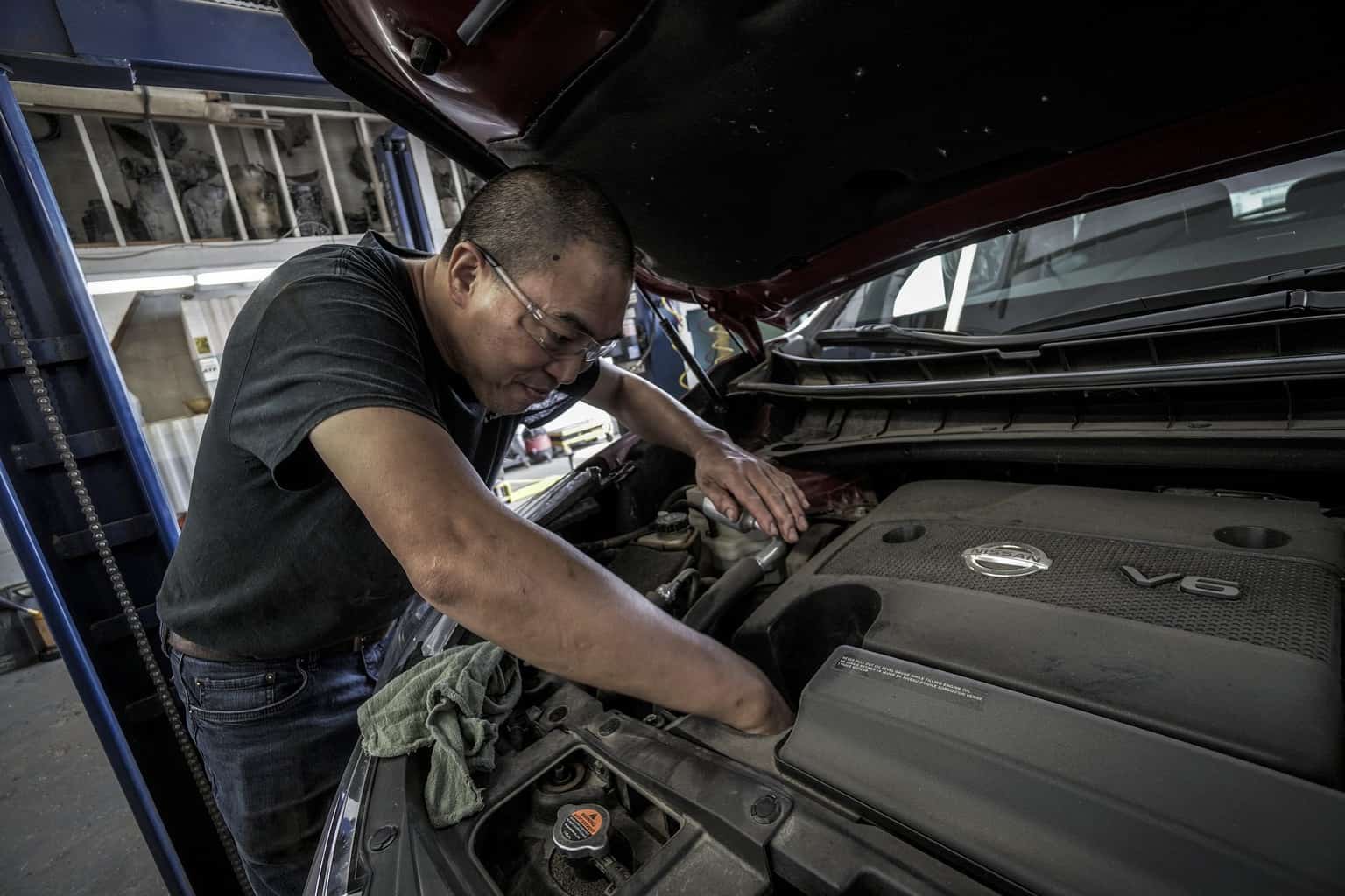 A man changing the oil of a car