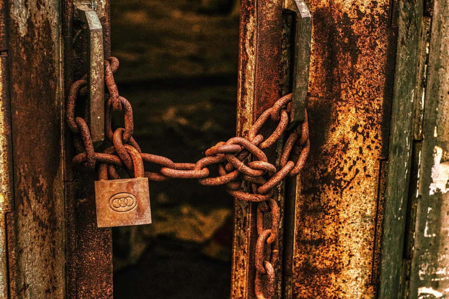A door with a lock and a chain full of rust