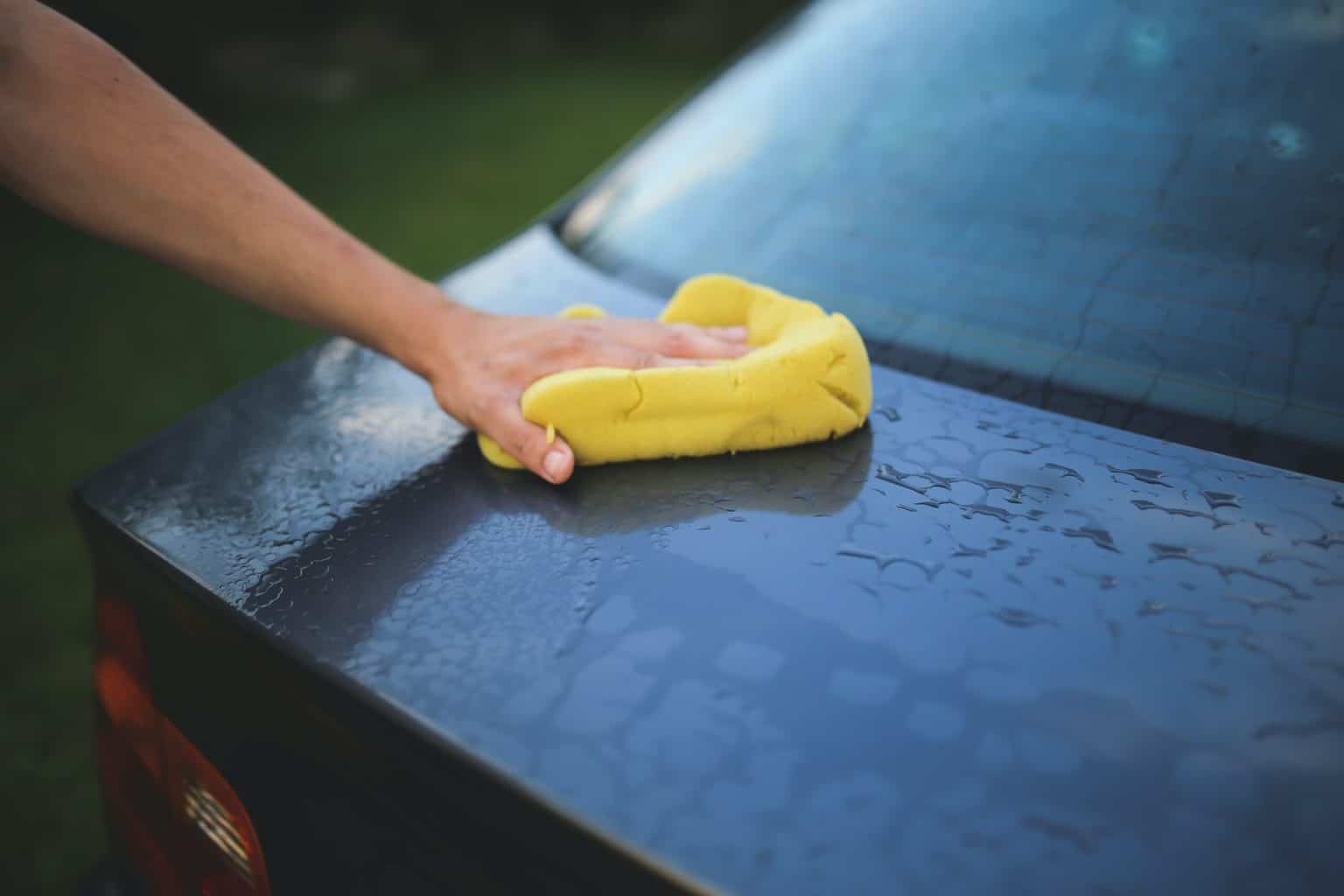 Wiping the back of the car witha yellow towel