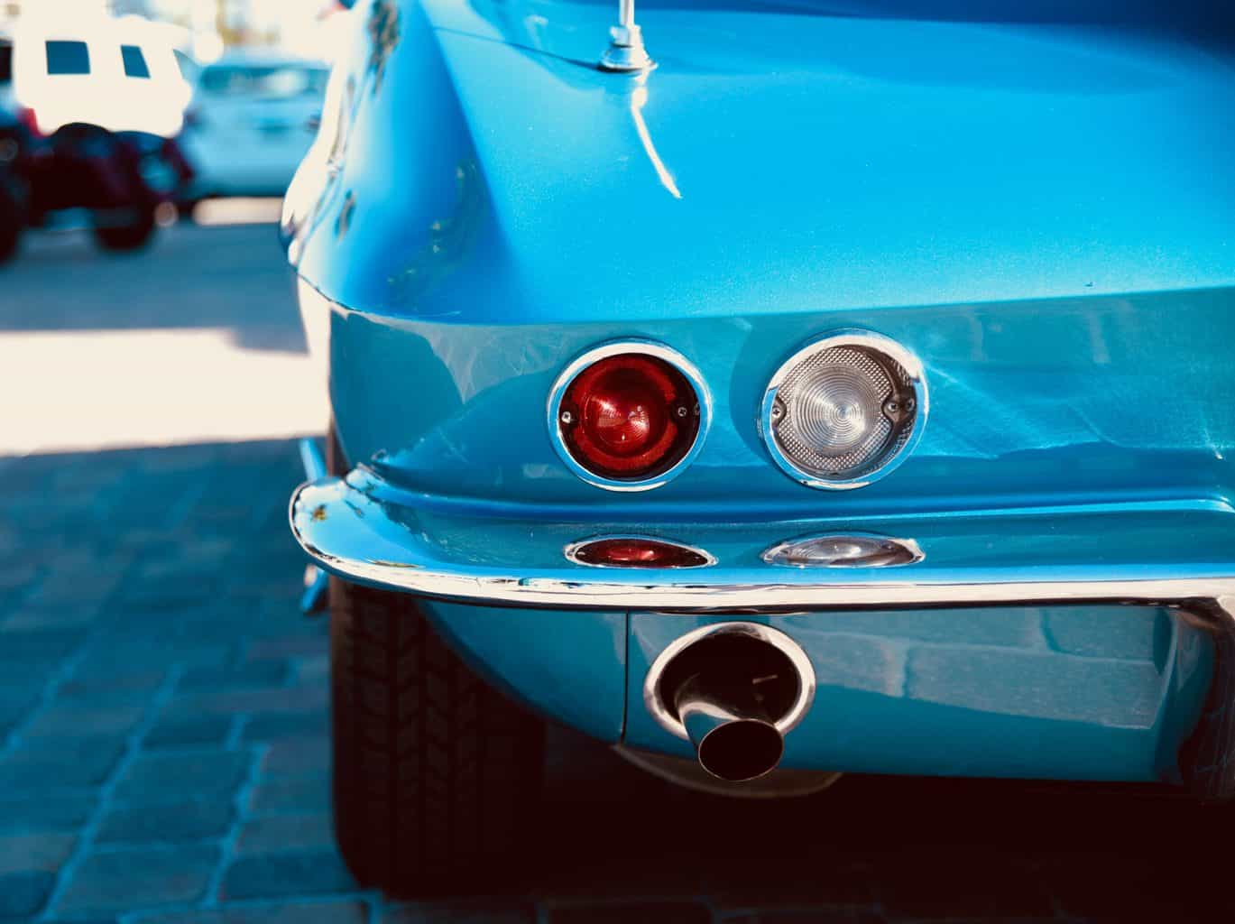 A rear view of a blue car with exhaust