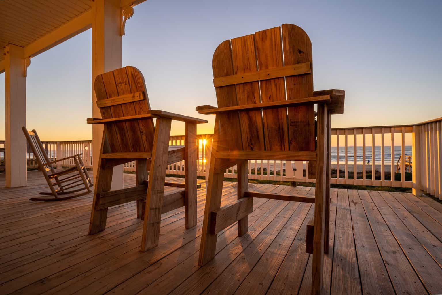 Two outdoor wooden chairs with sunset