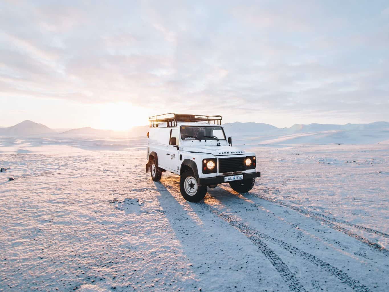 A jeep with sun on horizon