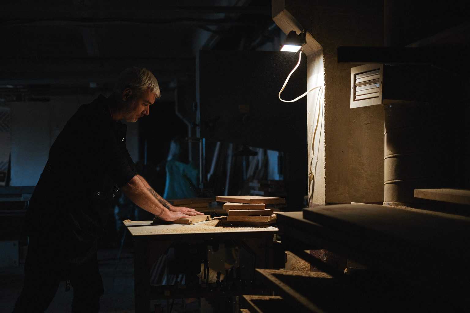 A man handling wood with small light