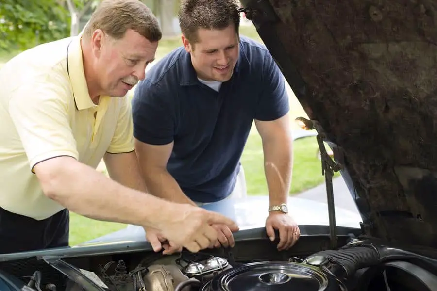 Father and son fixing car engine