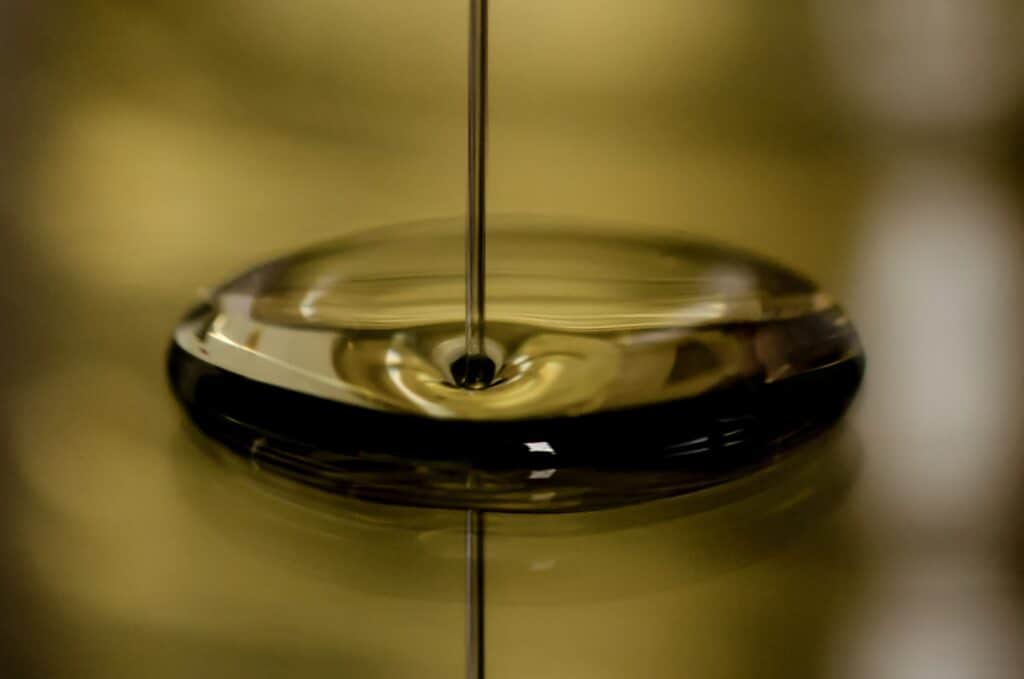Oil being poured on a gold surface