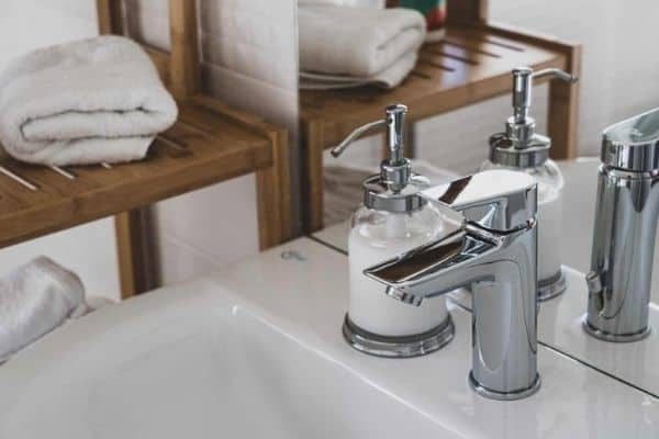 A porcelain sink with a chrome faucet and a soap dispenser