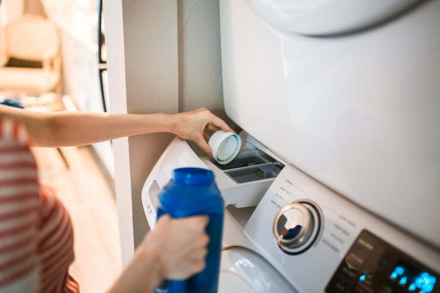 Person putting a laundry degreaser in the washing machine