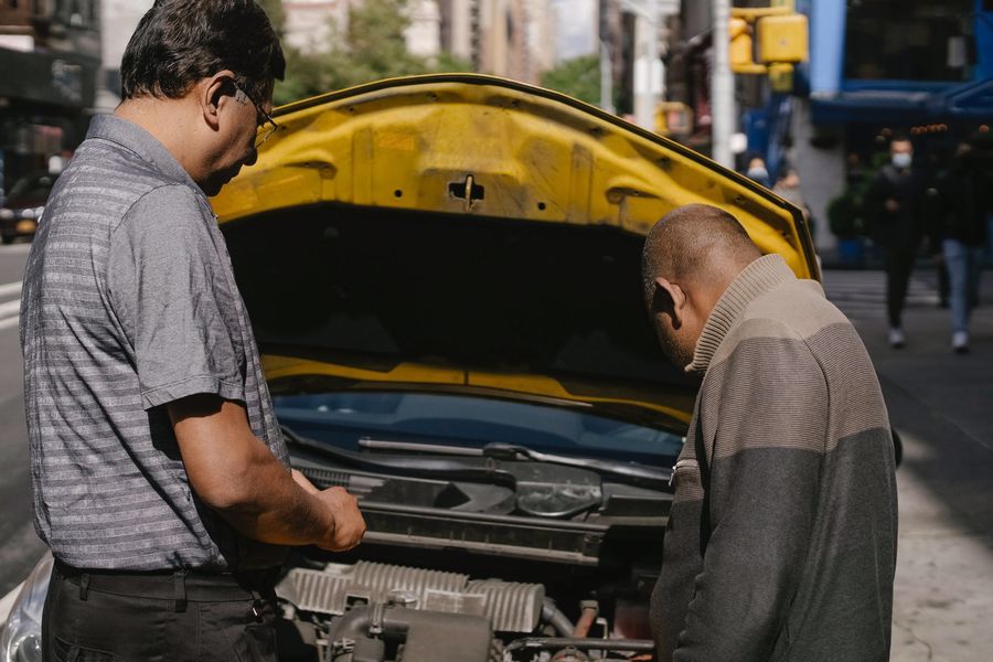 Two men checking the car's engine